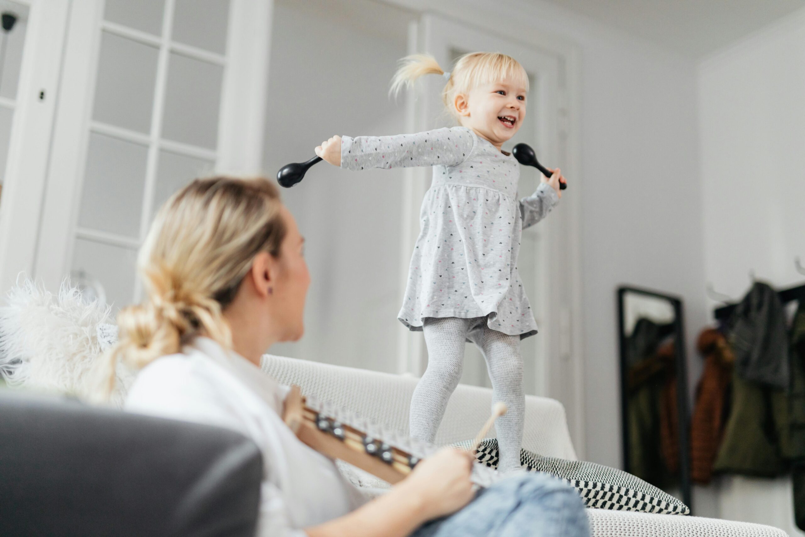 A lively toddler enjoying playtime on the sofa, creating happy family moments indoors.
